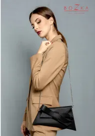 Czarna skórzana torebka z dużą kokardą.