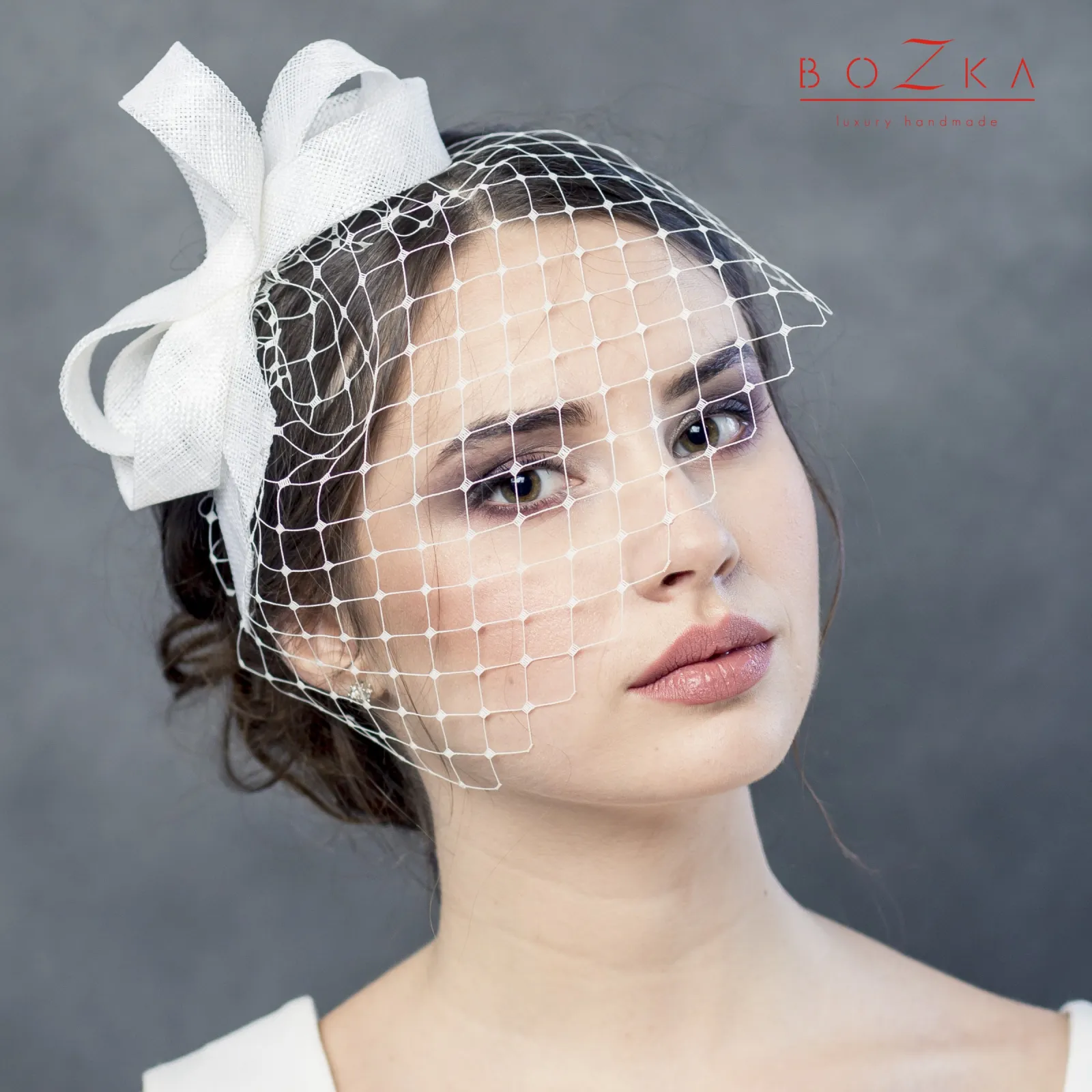 Ślubna kokarda we włosy z krótką woalką.