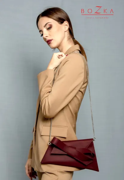 Bordowa torebka wizytowa na łańcuszku.