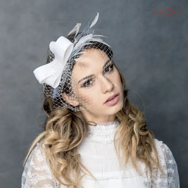 Fascynator ślubny z woalką i piórkami.
