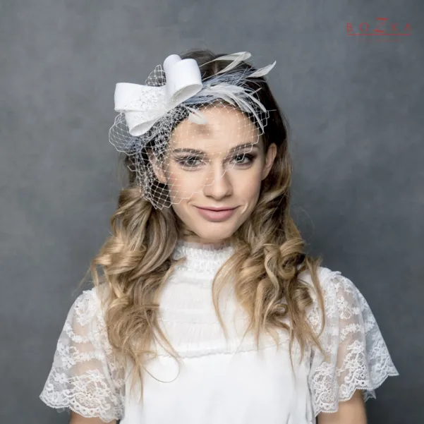Fascynator ślubny z woalką i piórkami.