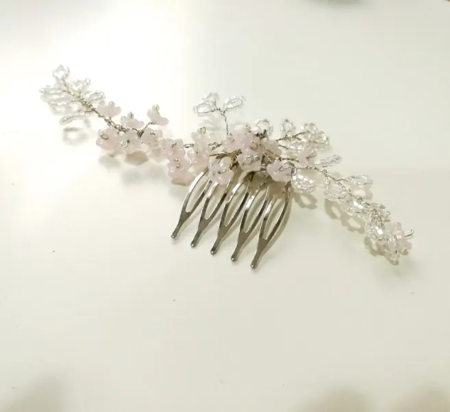 Srebrny grzebyk ślubny z kwiatkami i listkami.